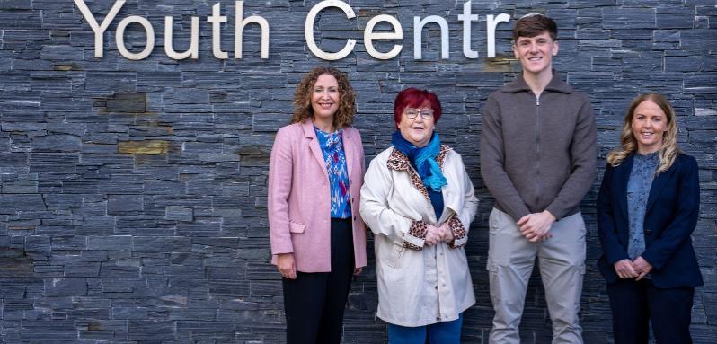 Image shows two academics, a local resident and a community worker pictured at an event.